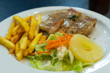 Chicken steak with French fries and salad.