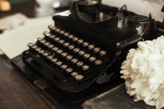Old black typewriter with paper worth on the table