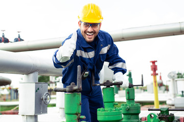 Worker closes the valve on the oil pipeline