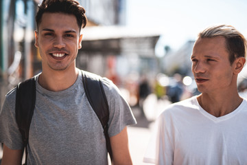 Obraz premium Portrait of beaming male telling with orderly man while going at street