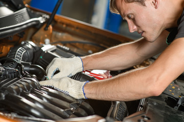 Fototapeta na wymiar young mechanic repairs the car engine