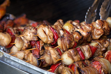 Close up of traditionally grilled pork and beef meat on a wooden stick. Eastern European traditional shish kebab with grilled vegetables.