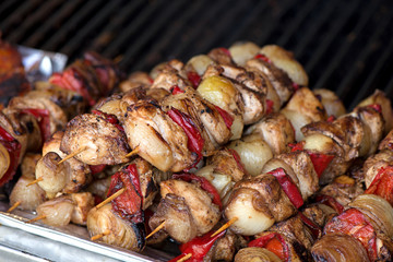 Close up of traditionally grilled pork and beef meat on a wooden stick. Eastern European traditional shish kebab with grilled vegetables.