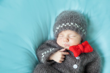 Sleeping newborn baby in a crocheted gingerbread man costume