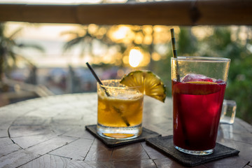 tropical drinks on table with palm trees in background