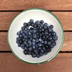  Blueberries in a bowl on a wooden surface