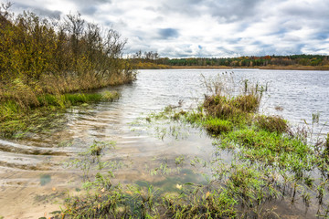 Lake landscape and autumn forest, bad weather with clouds