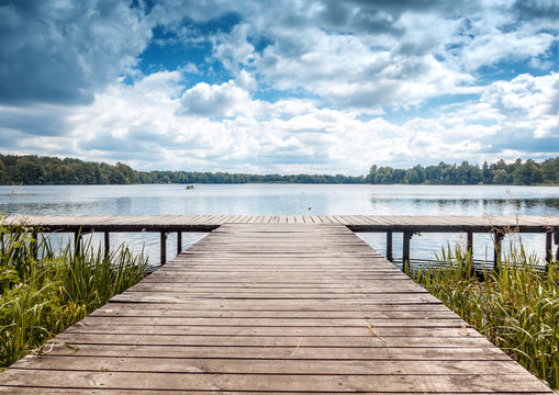 Fototapeta Beautiful summer landscape with dramatic sky, wooden pier on the lake, Trakai, Lithuania