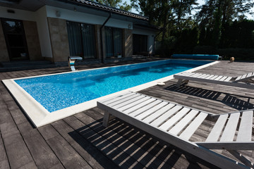 view of house exterior, swimming pool with sunbeds