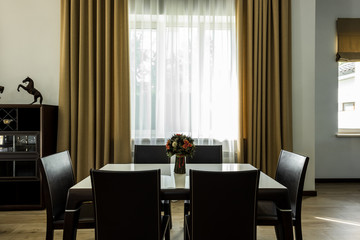 interior view of stylish dining room with table, chairs and big window