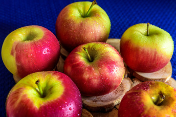 Six fresh red apples on blue background. Useful for grocery store advertising.
