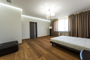 interior of modern bedroom with big window and mattress on bed