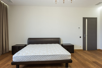 interior of bedroom with white mattress on bed