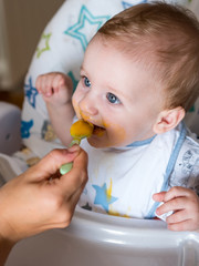 Mom feeding cute redhead boy wiht blue eyes top view