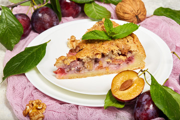 Delicious sweet pie with plums and walnuts. Closed pie. Sweet autumn dessert.