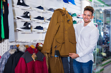 Couple examining various coats in sports store