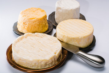 French AOC soft cow cheeses, crumbly Langres with washed rind structure, sharp Pie Angloys, camembert with strong taste and brie served as dessert after dinner