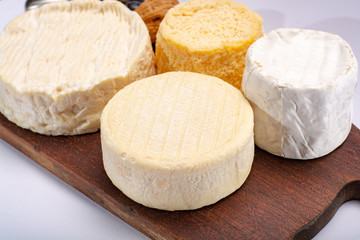 French AOC soft cow cheeses, crumbly Langres with washed rind structure, sharp Pie Angloys, camembert with strong taste and brie served as dessert after dinner