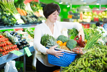 Adult female taking vegetables with basket