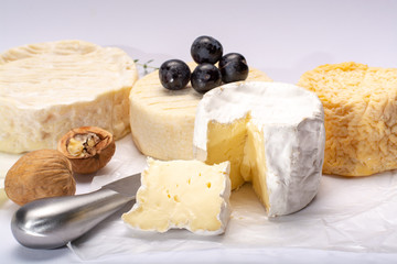 French AOC soft cow cheeses, crumbly Langres with washed rind structure, sharp Pie Angloys, camembert with strong taste and brie served as dessert after dinner
