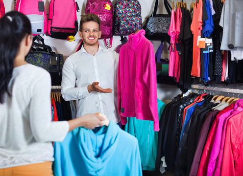 Couple examining various sports clothes in sports store