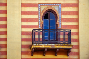 Decorative window in spanish style on the striped wall