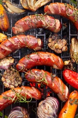 Fototapeten Grilled sausages and vegetables with addition spices and fresh herbs on a grill plate, top view © zi3000