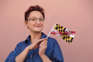 Maryland flag. Woman holding Maryland state flag. Nice portrait of middle aged lady 40 50 years old...