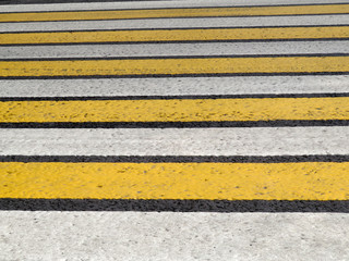 Pedestrian crossing background. Yellow and white lines of a zebra crosswalk on the pavement