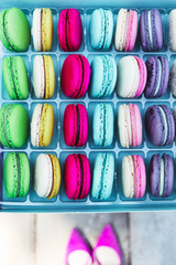 Pink shoes and a macaroons box. Luxury temptation concept. Top view.