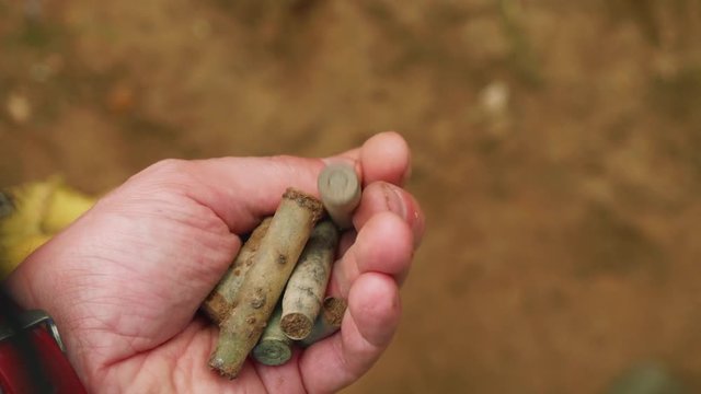 View of bulet, shell casing of german machine gun MG-42б, of handgun and rifle in man's hand