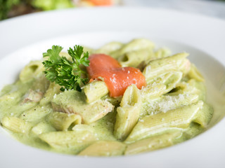 Traditional Italian Penne pasta with pesto sauce and salmon.