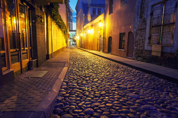 Vilnius, the capital of Lithuania at sunset, paved street in the historic center of the city at night
