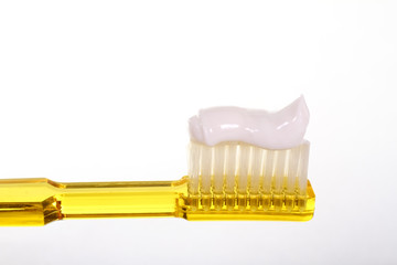 Close up of a toothbrush with toothpaste isolated on a white background with space for copy