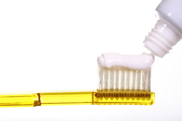 Close up of a toothbrush with toothpaste isolated on a white background with space for copy