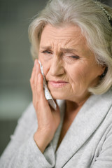 Close up portrait of senior woman with toothache