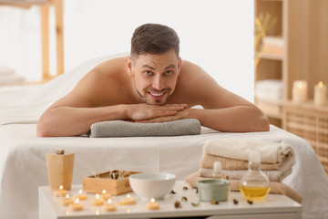 Obraz na płótnie Canvas Man lying on massage table in spa salon