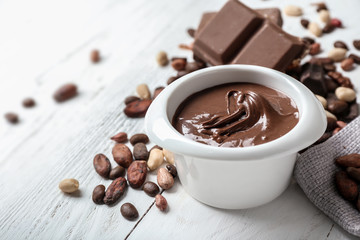 Bowl with molten chocolate on wooden table
