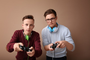 Teenagers with gamepads on color background © Pixel-Shot