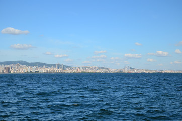 View to Istanbul from Prince's Islands (B&uuml;y&uuml;kada). Sea cityscape with modern skyscrapers of Istanbul. Beautiful blue sky with white clouds