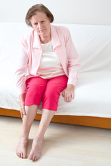 Seniorin massiert ihr Bein