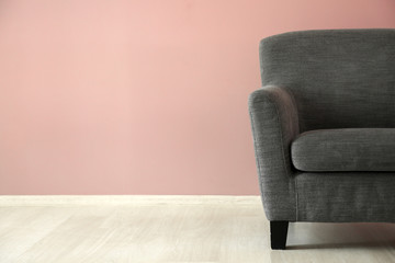 Comfortable armchair near color wall
