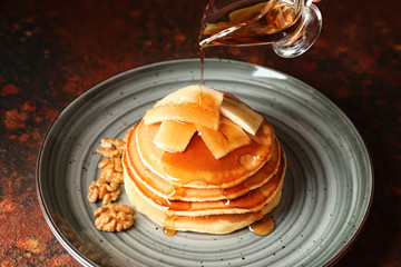 Pouring of syrup onto tasty pancakes