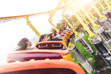 the abstract image of the roller coaster running on the rail in amusement park. the concept of extreme, fun, holiday and vacation. - obrazy, fototapety, plakaty