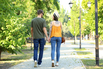 Happy lovely couple walking in park on sunny day