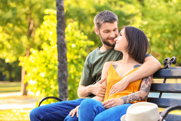 Happy lovely couple resting in park on sunny day