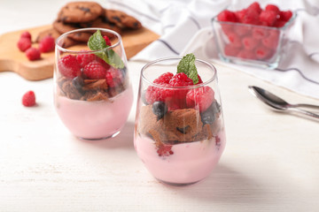 Glasses with tasty raspberry dessert on table