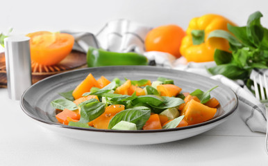 Plate with fresh vegetable salad on white table