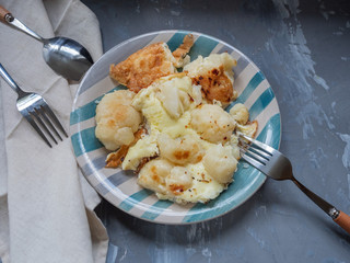 Freshly cooked omelette with cauliflower on a striped ceramic plate close-up