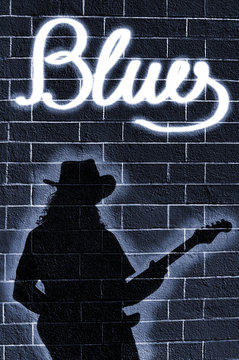 Shadow of musician whit guitar on brick wall 